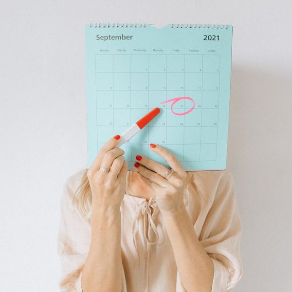 Calendar with a highlighted date and a yoga mat next to it.